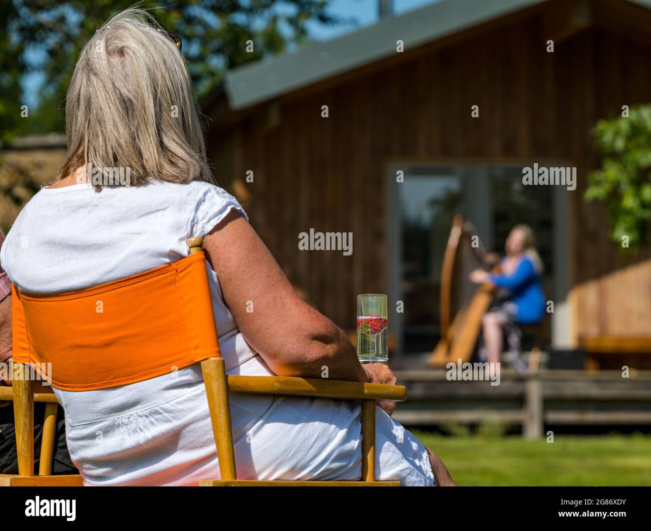 Haddington, East Lothian, Scozia, Regno Unito, 17 luglio 2021. L'arpista celtica Ailie Robertson suona nel giardino murato di Amisfield: Un concerto socialmente distanziato si svolge nel giardino murato gestito da volontari, uno dei più grandi della Scozia. Ailie Robertson è un premiato compositore e performer che suona musica tradizionale e contemporanea arpa Foto Stock