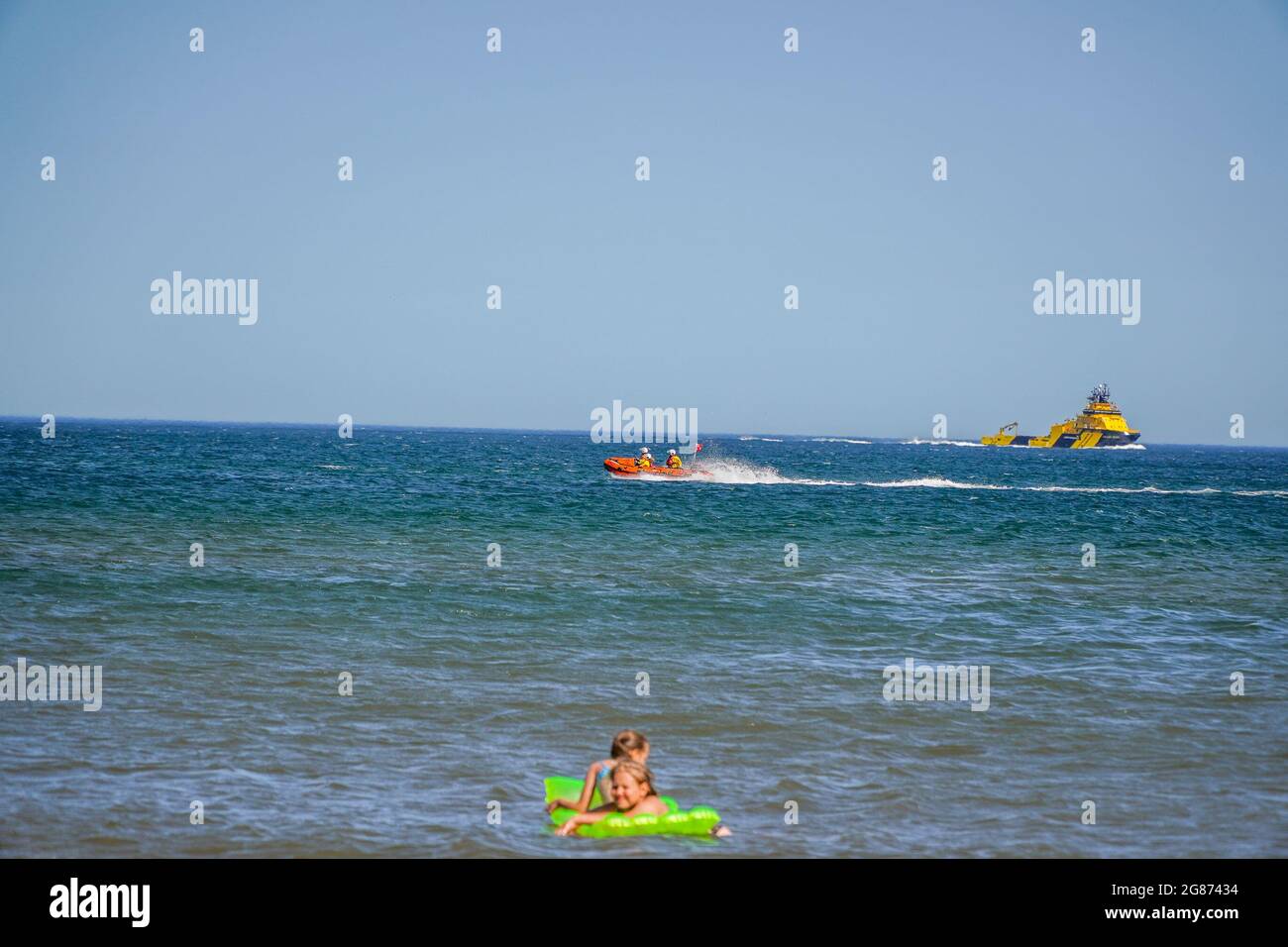 Lunan Bay Beach, Angus, Scotland, UK, 17 luglio 2021: Importante operazione di salvataggio effettuata dalla guardia costiera e RNLI, dopo che una mamma e una figlia si sono allontanate in mare sul loro gommone in forte vento oggi a Lunan Bay Beach. Una nave di rifornimento offshore, che si trovava nelle vicinanze, ha anche lanciato il suo FRC per aiutare nel salvataggio. In questa foto è possibile vedere la nave di salvataggio costiera RNLI che effettua una ricerca lungo la costa, mentre la nave di rifornimento offshore si avvicina alla linea costiera. (Credit: Notizie dal vivo Barry Nixon/Alamy) Foto Stock