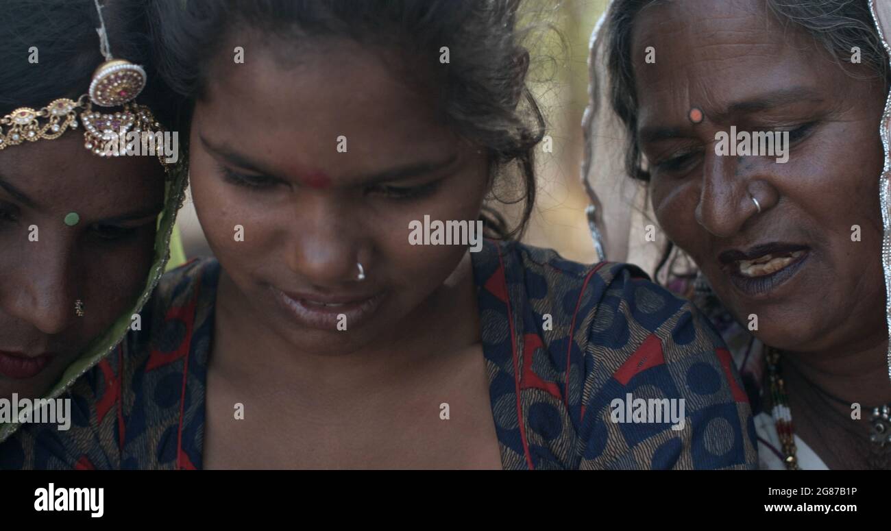 Le donne indiane in abbigliamento tradizionale assorbite con qualcosa di interessante Foto Stock