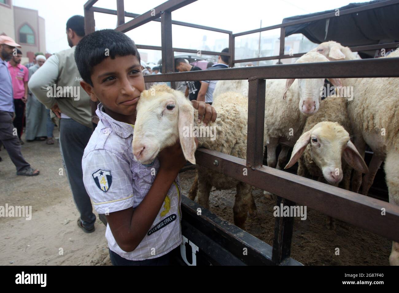 Rafah, Gaza. 17 luglio 2021. Un ragazzo palestinese gioca con animali sacrificali in un mercato del bestiame davanti all'Eid al-Adha, a Rafah nella striscia di Gaza meridionale, sabato 17 luglio 2021. I musulmani di tutto il mondo celebrano Eid al-Adha visitando le tombe dei loro cari e macellando pecore, capre, mucche e cammelli, in commemorazione della disponibilità del profeta Abramo a sacrificare suo figlio Ismail su comando di Dio. Foto di Ismael Mohamad/UPI Credit: UPI/Alamy Live News Foto Stock