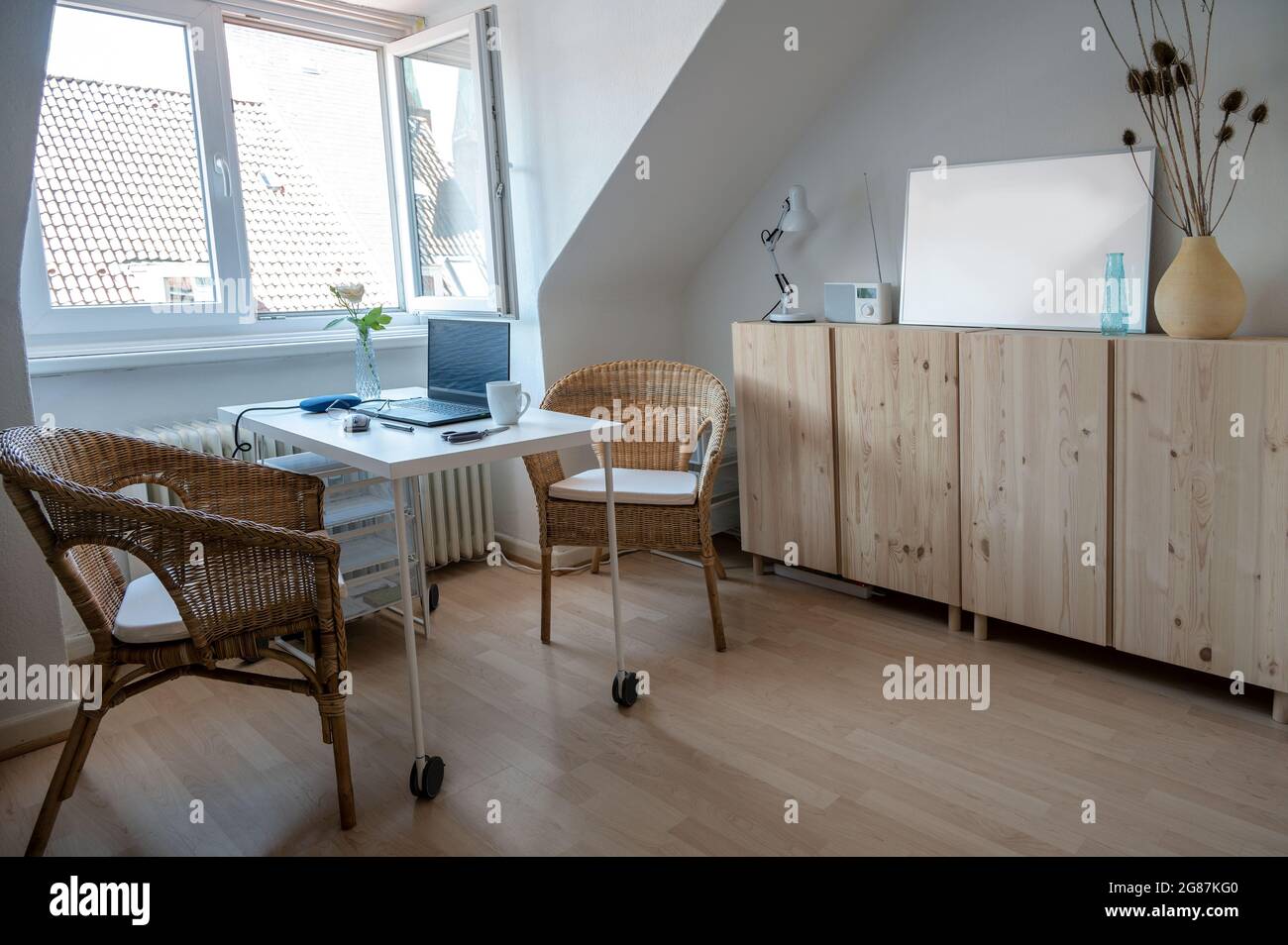 Piccolo appartamento mansardato con un tavolo da lavoro stretto per l'ufficio domestico, concetto per l'alloggio e il design interno in una proprietà affittata, fuoco selezionato Foto Stock