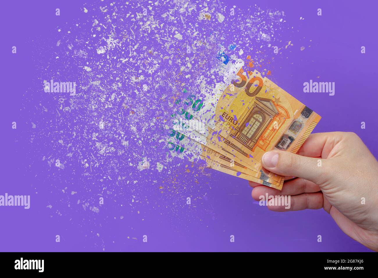 inflazione euro . Inflazione in Europa, iperinflazione. Banner con sfondo viola. Cinquanta banconote in euro spruzzate in mano a un uomo su un porpora Foto Stock