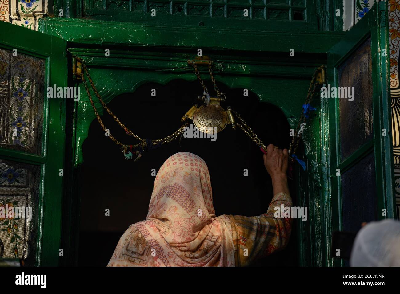 Srinagar, India. 17 luglio 2021. Una donna musulmana del Kashmiri prega fuori dal santuario di Sufi San Syed Ali Hamadani durante i suoi urs a Srinagar.centinaia di musulmani del Kashmiri si sono riuniti a Shrines per commemorare l'anniversario della morte di un famoso santo sufi, Mir Syed Ali Hamadani. Credit: SOPA Images Limited/Alamy Live News Foto Stock