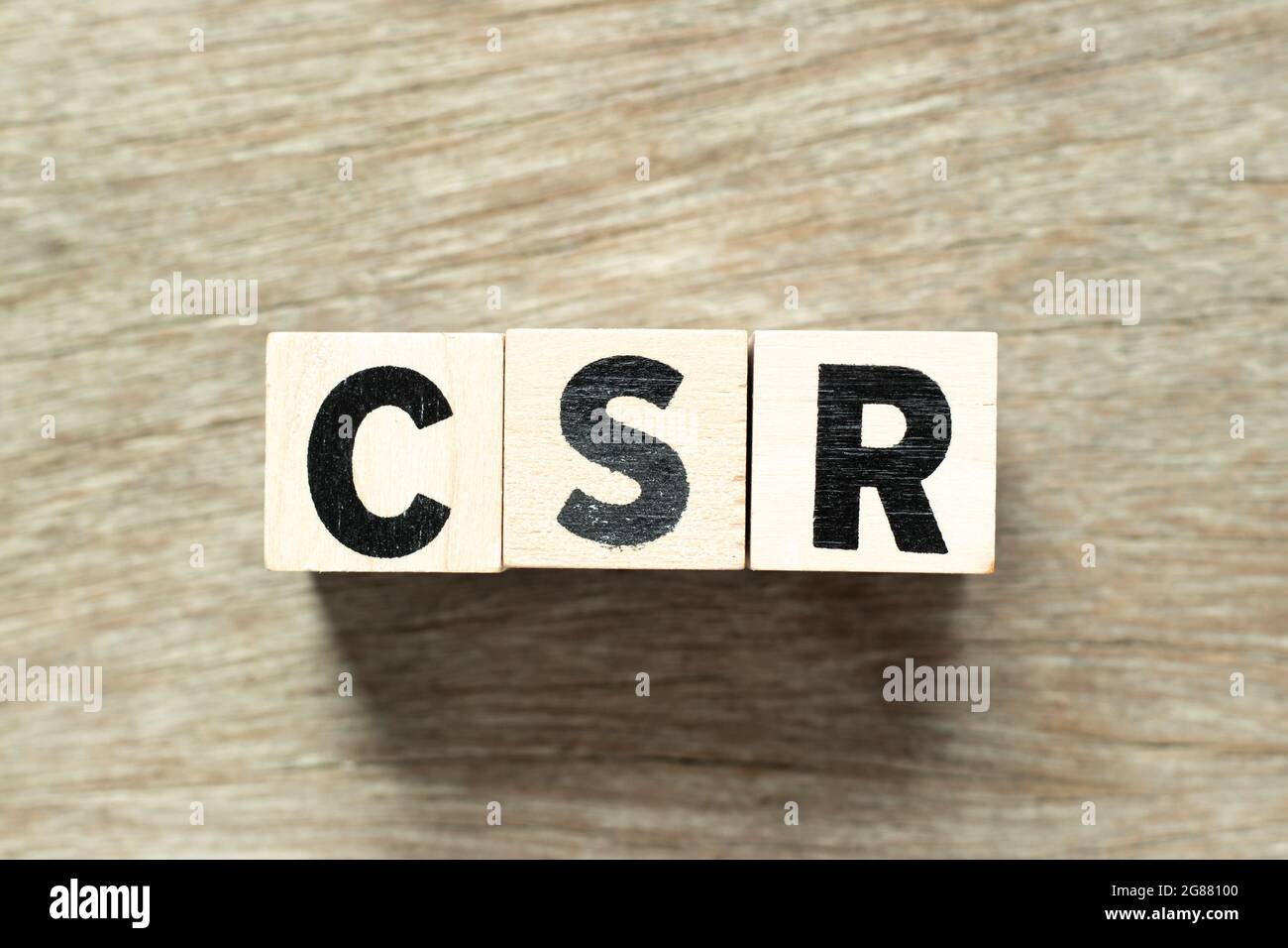Blocco di lettere in parola CSR (abbreviazione di responsabilità sociale d'impresa) su sfondo di legno Foto Stock