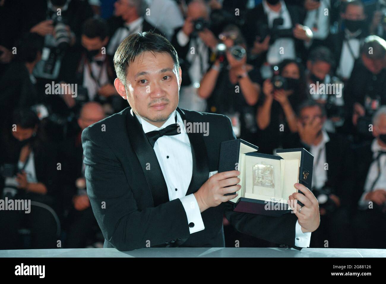 Ryusuke Hamaguchi si pone con il "miglior Screenplay Award" per "Drive my Car" durante i vincitori Photocall come parte del 74a Festival Internazionale del Cinema di Cannes, in Francia, il 17 luglio 2021. Foto di Aurore Marechal/ABACAPRESS.COM Foto Stock