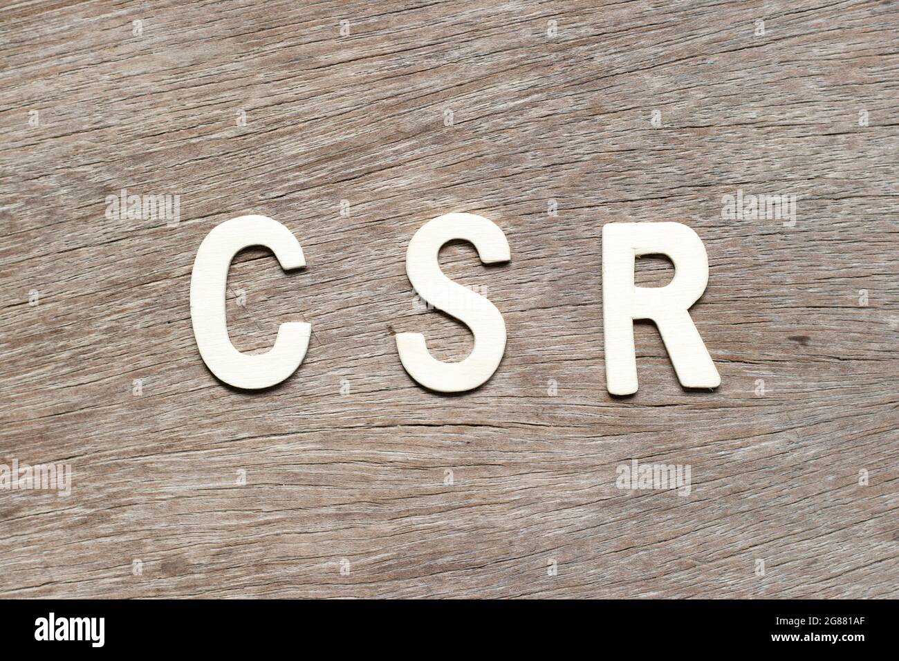 Lettera alfabetica in parola CSR (abbreviazione della responsabilità sociale d'impresa) su sfondo di legno Foto Stock