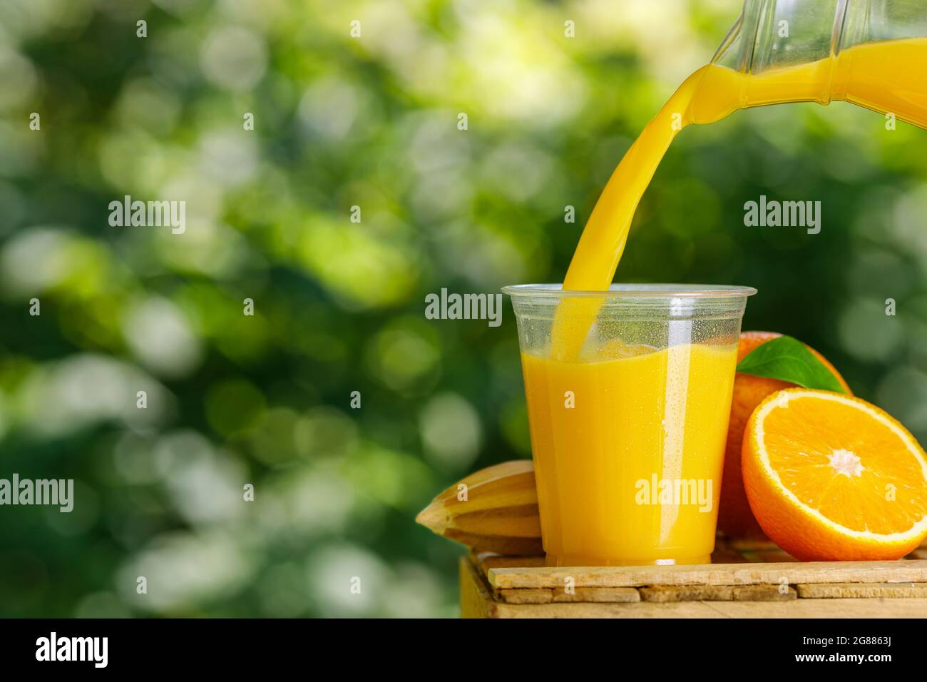 bicchiere monouso in plastica di succo d'arancia fresco spremuto Foto Stock