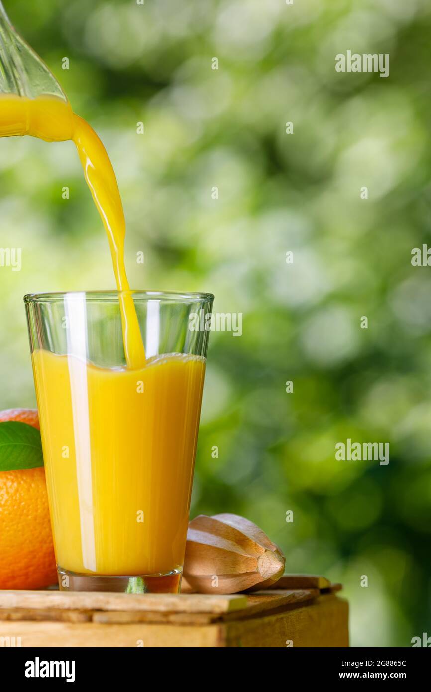 succo d'arancia fresco versato in vetro all'aperto Foto Stock