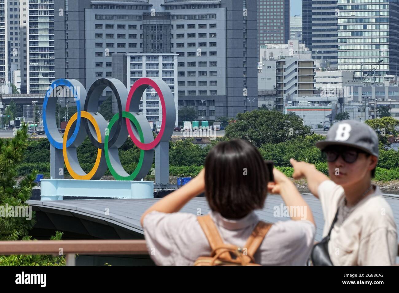 Tokio, Giappone. 18 luglio 2021. Due persone scattano una foto di se stessi davanti agli anelli olimpici. Le Olimpiadi di Tokyo 2020 si terranno dal 23.07.2021 al 08.08.2021. Credit: Michael Kappeler/dpa/Alamy Live News Foto Stock