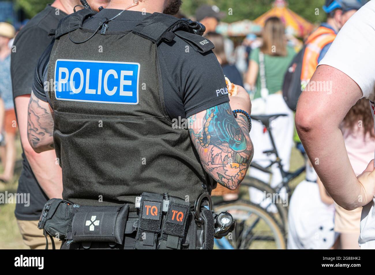 Un ufficiale di polizia molto tatuato ad un festival di cibo e bevande. Foto Stock
