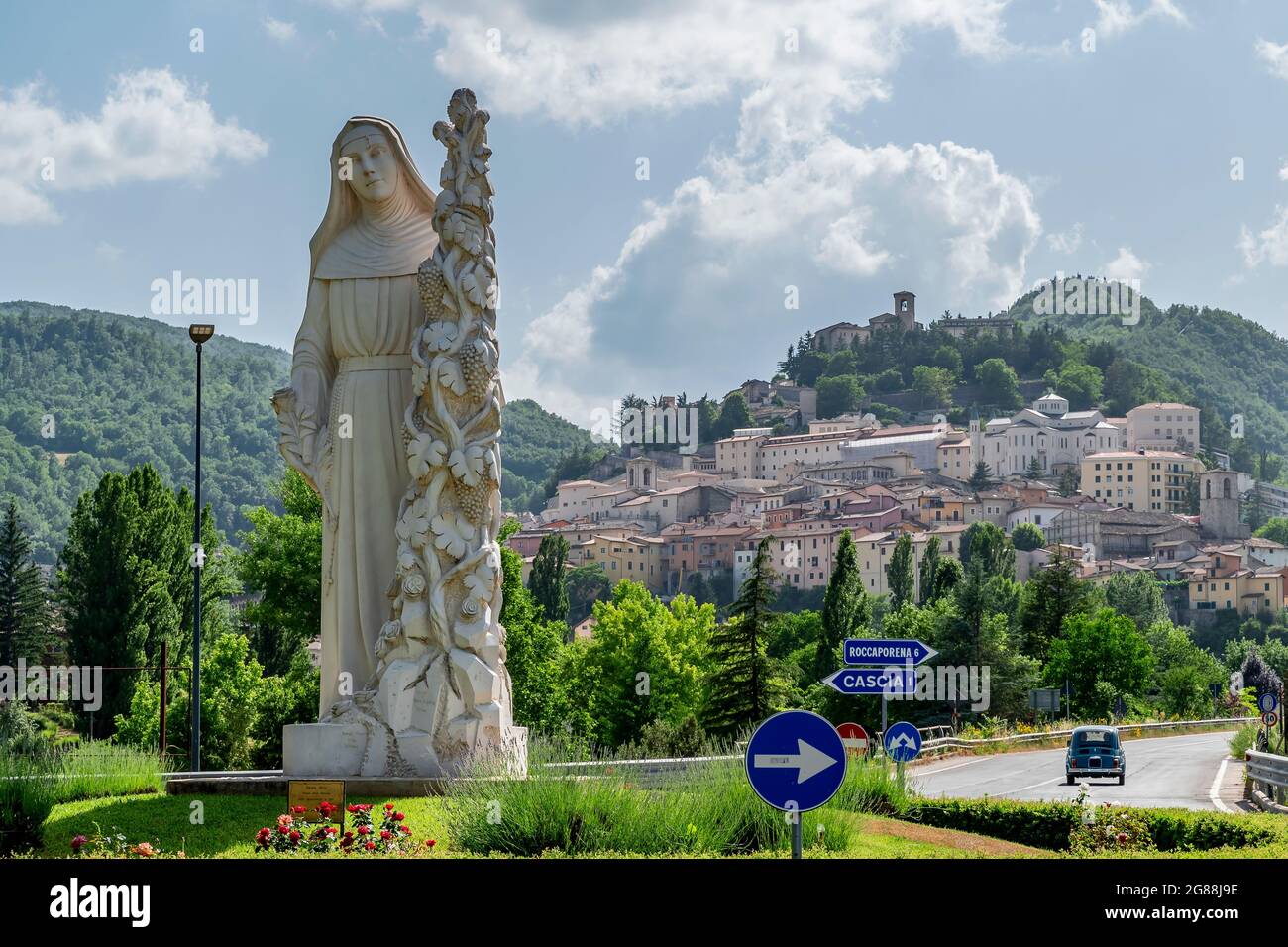La statua di Santa Rita da Cascia accoglie i fedeli all'ingresso del paese, Cascia, Italia Foto Stock