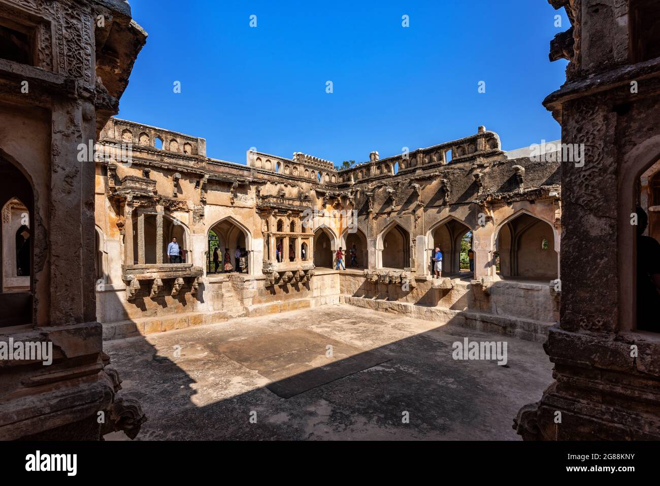 Hampi, Karnataka, India - 14 Gennaio 2020 : la struttura del bagno delle Regine dell'Impero Vijayanagara. 3 lati della piscina quadrata asciutta con le sue pareti, corridoi an Foto Stock