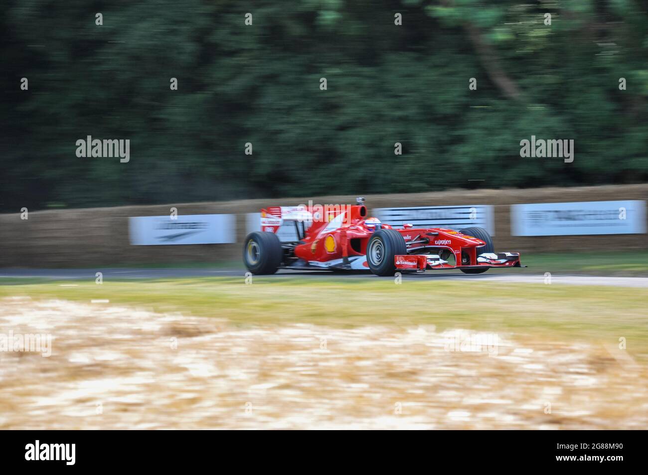Ferrari F10 Formula 1, vettura da corsa Grand Prix al Goodwood Festival of Speed 2013 che corre in salita sulla pista a velocità. Sezione legno Foto Stock