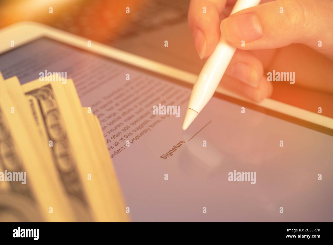 Firma del contatto con la firma elettronica sul tablet. Business successo concept foto con soldi Foto Stock