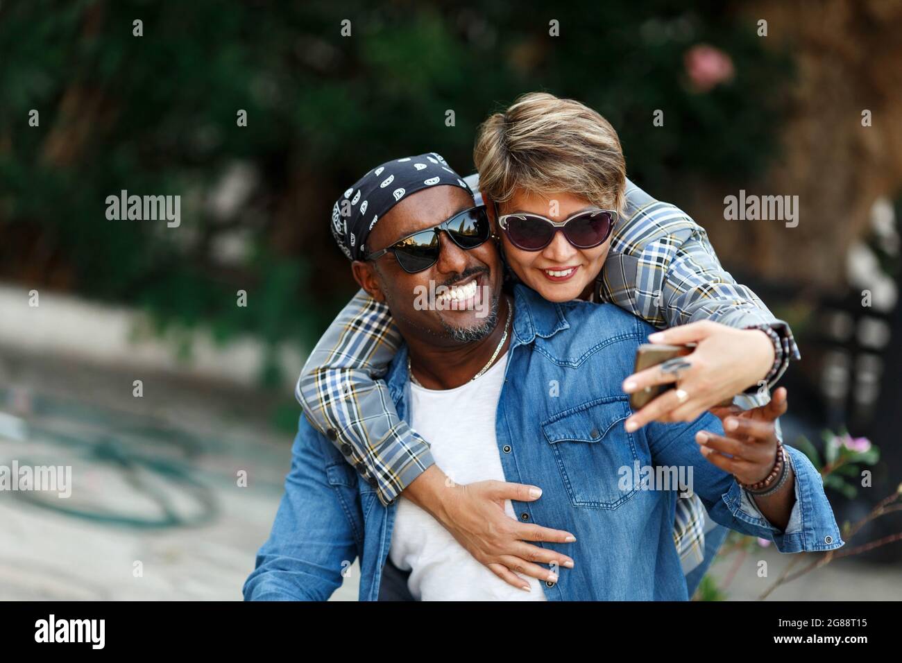Momenti felici. Coppia allegra nera che prende Selfie sullo smartphone mentre ha viaggio romantico di data, sposi afroamericani di mezza età in viaggio. Misto Foto Stock