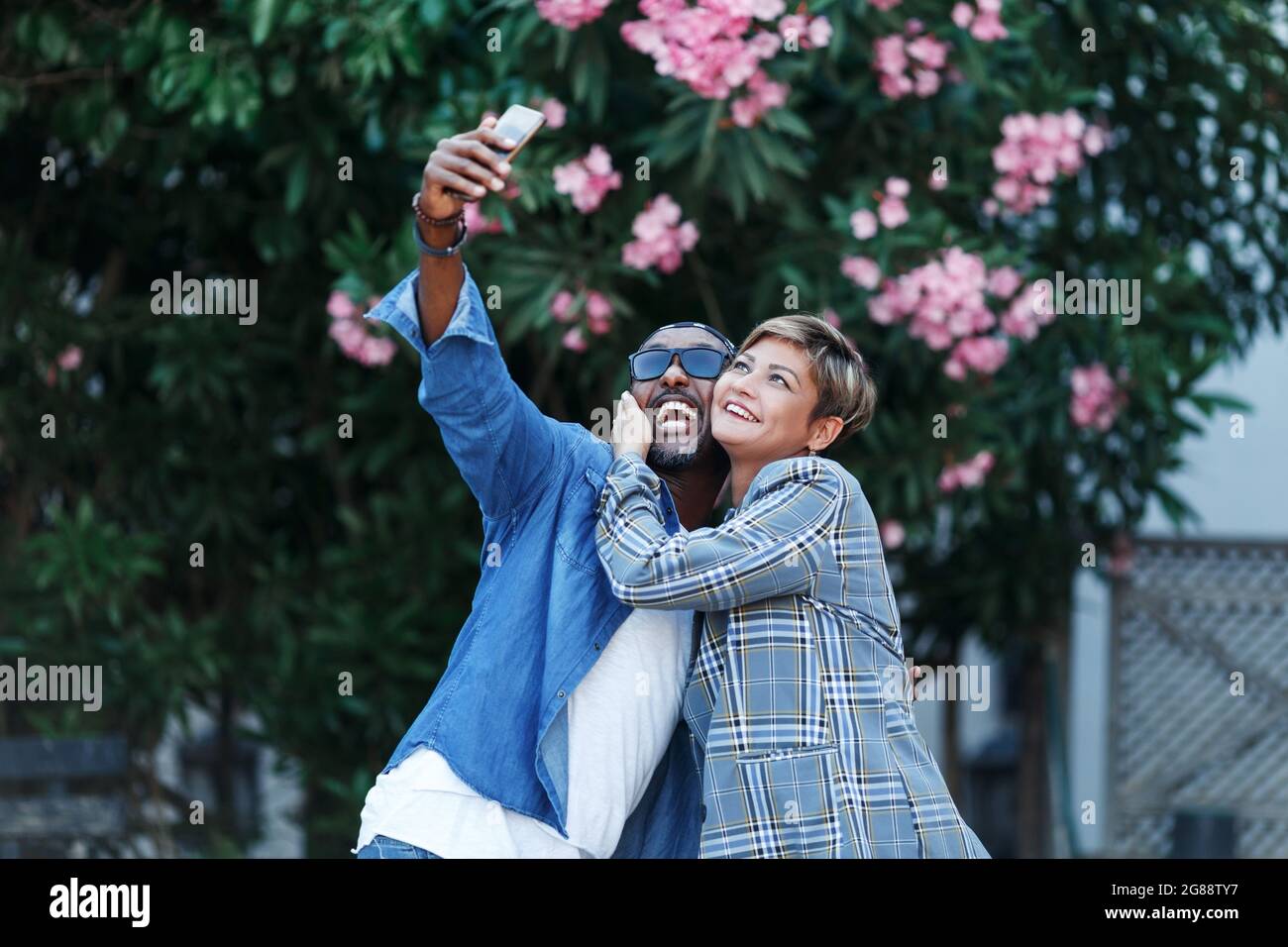 Momenti felici. Coppia allegra nera che prende Selfie sullo smartphone mentre ha viaggio romantico di data, sposi afroamericani di mezza età in viaggio. Misto Foto Stock