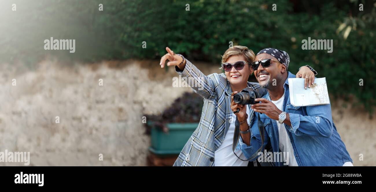 Momenti felici. Coppia di pelle scura allegra che scatta sopra la macchina fotografica mentre ha viaggio romantico di data, sposi afroamericani di mezza età in viaggio. Donna Foto Stock