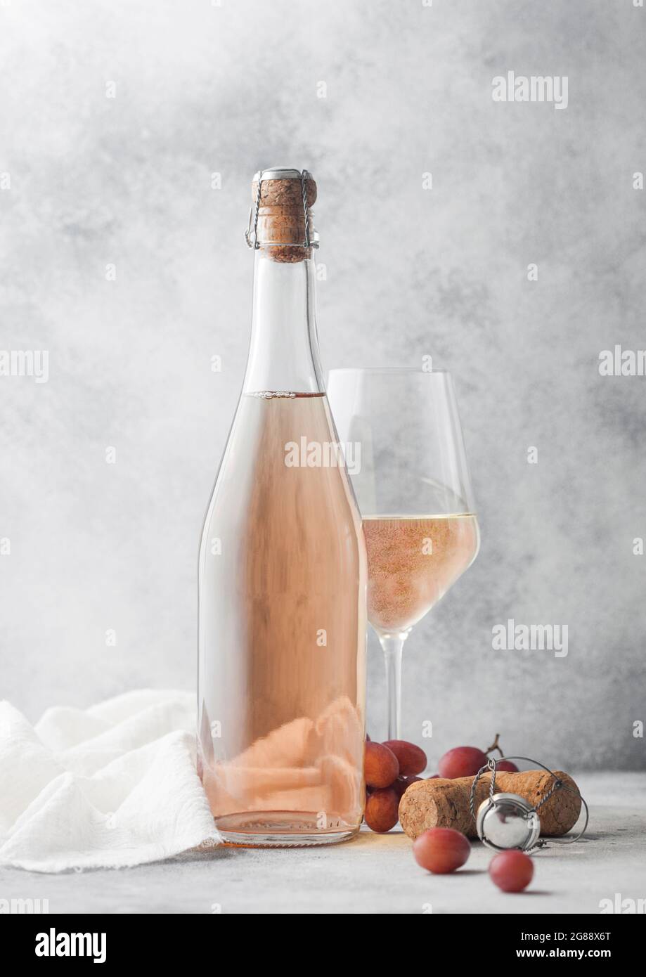 Bottiglia e bicchiere di vino rosa fatto in casa con uva e cavatappi con  panno di lino su sfondo chiaro Foto stock - Alamy