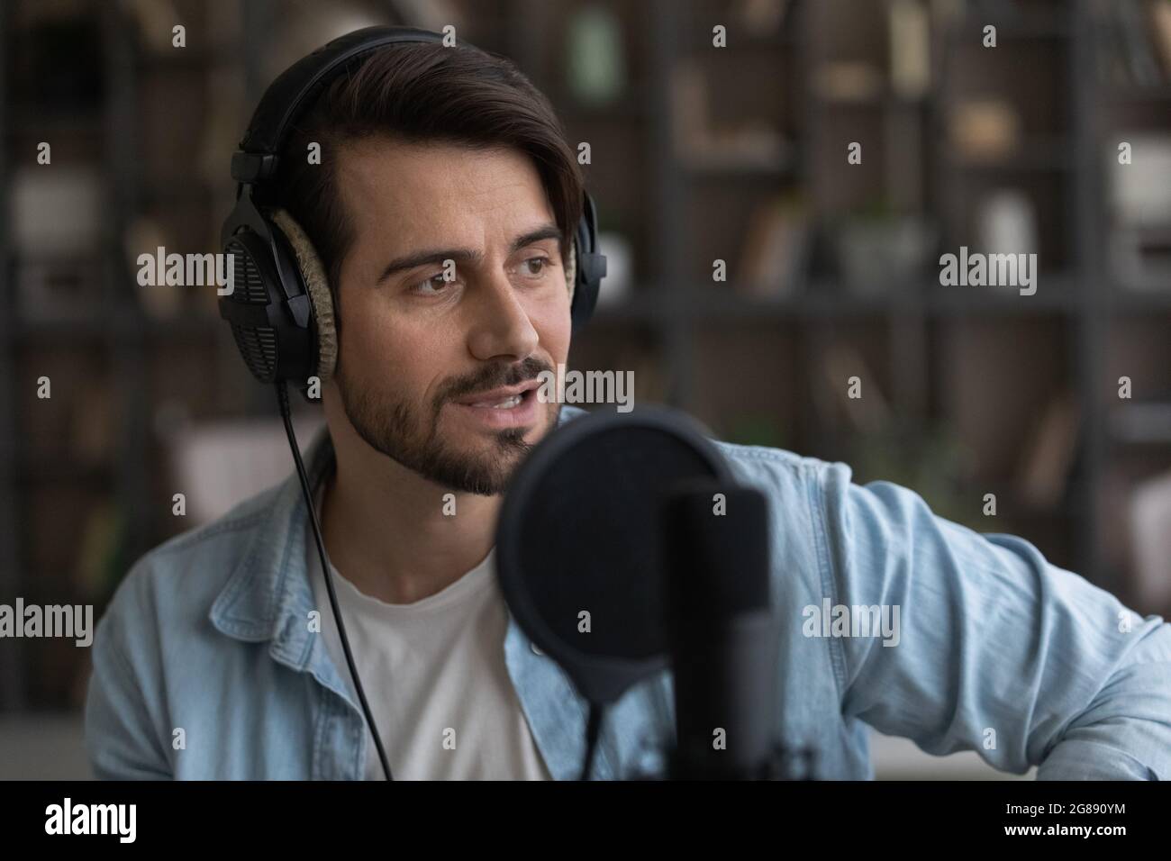 Canzone creativa di un giovane uomo in microfono professionale. Foto Stock