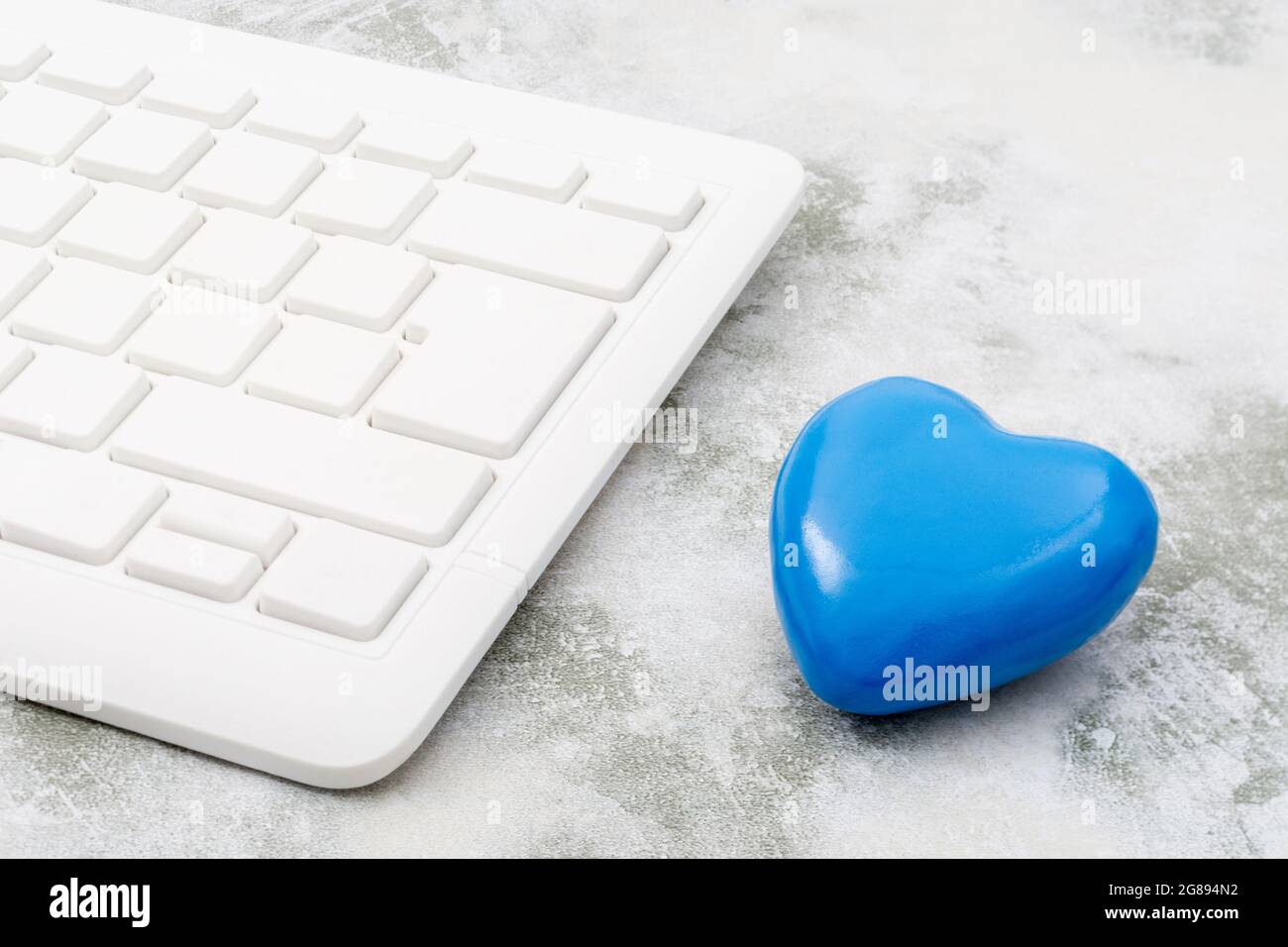 Cuore blu + tastiera Qwerty bianca per il lunedì blu, sensazione di cupo / disprezzo, cattivo morale degli uffici, in corso di dumping online, Covid blocco mentale blues. Foto Stock