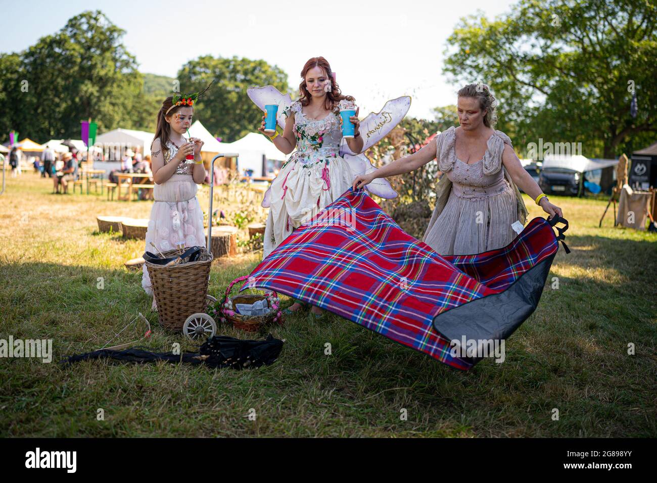 Una famiglia lancia un tappeto da picnic come si ombreggiano dal sole a Fantasy Forest, un festival all'aperto al castello di Sudeley a Cheltenham, Che rimane l'unico castello privato in Inghilterra ad avere una regina sepolta all'interno dei giardini - la regina Katherine Parr, l'ultima e sopravvissuta moglie di re Enrico VIII - che ha vissuto e morto nel castello. Data immagine: Domenica 18 luglio 2021. Foto Stock