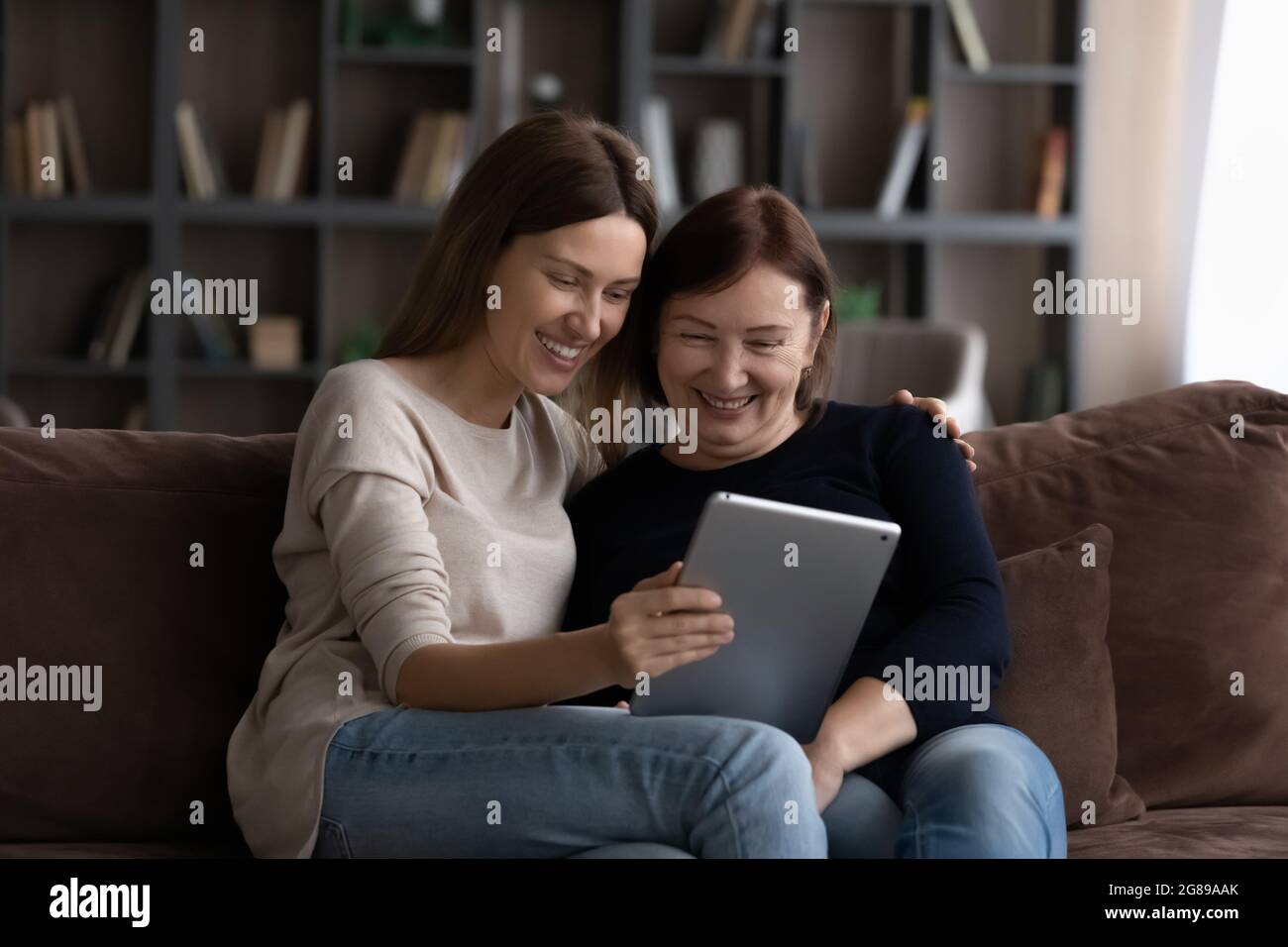 Felice figlia grunnup che mostra contenuti su tablet per la madre matura Foto Stock