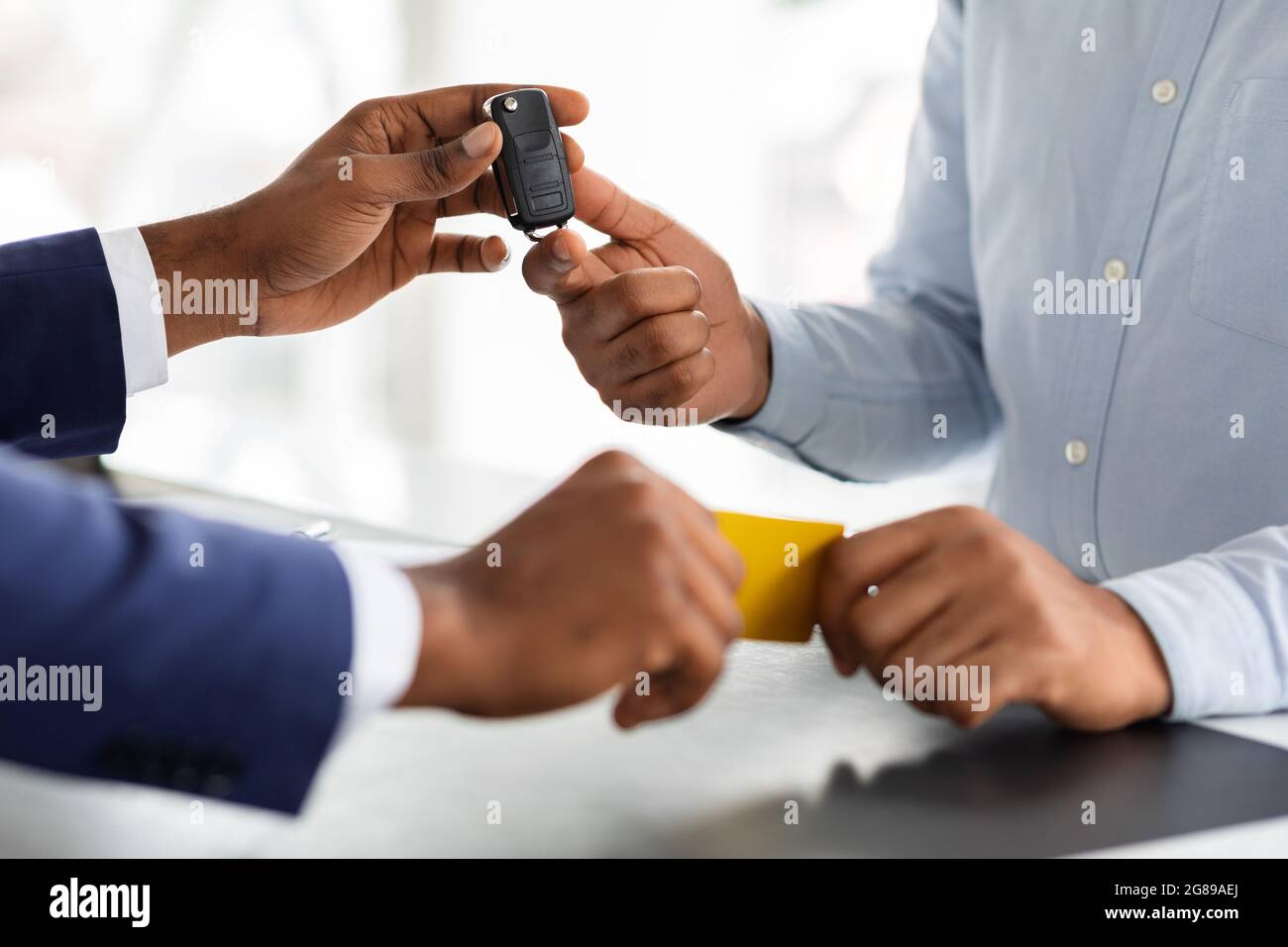 Acquisto di un veicolo. Uomo che dà la carta di credito al responsabile e prende le chiavi dell'automobile Foto Stock