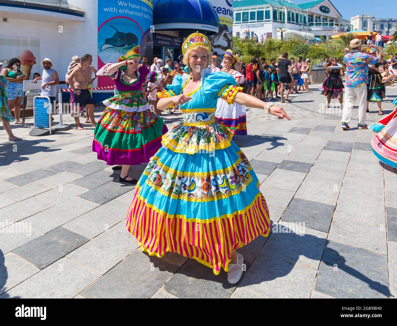 Bournemouth, Dorset, Regno Unito. 18 luglio 2021. Afon sistema con i loro ballerini strizzarri con gonne colorate giocano Maracatu, cugino Earthier di Samba del nord-est delle Brazilas si esibiscono come parte della serie estiva Arts by the Sea in una calda giornata di sole affollata sul mare. Credit: Carolyn Jenkins/Alamy Live News Foto Stock