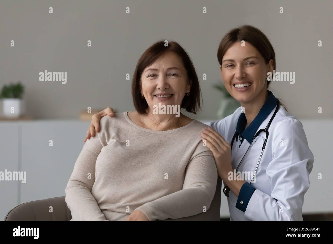 Buon medico e riconoscente paziente senior sorridente alla macchina fotografica Foto Stock