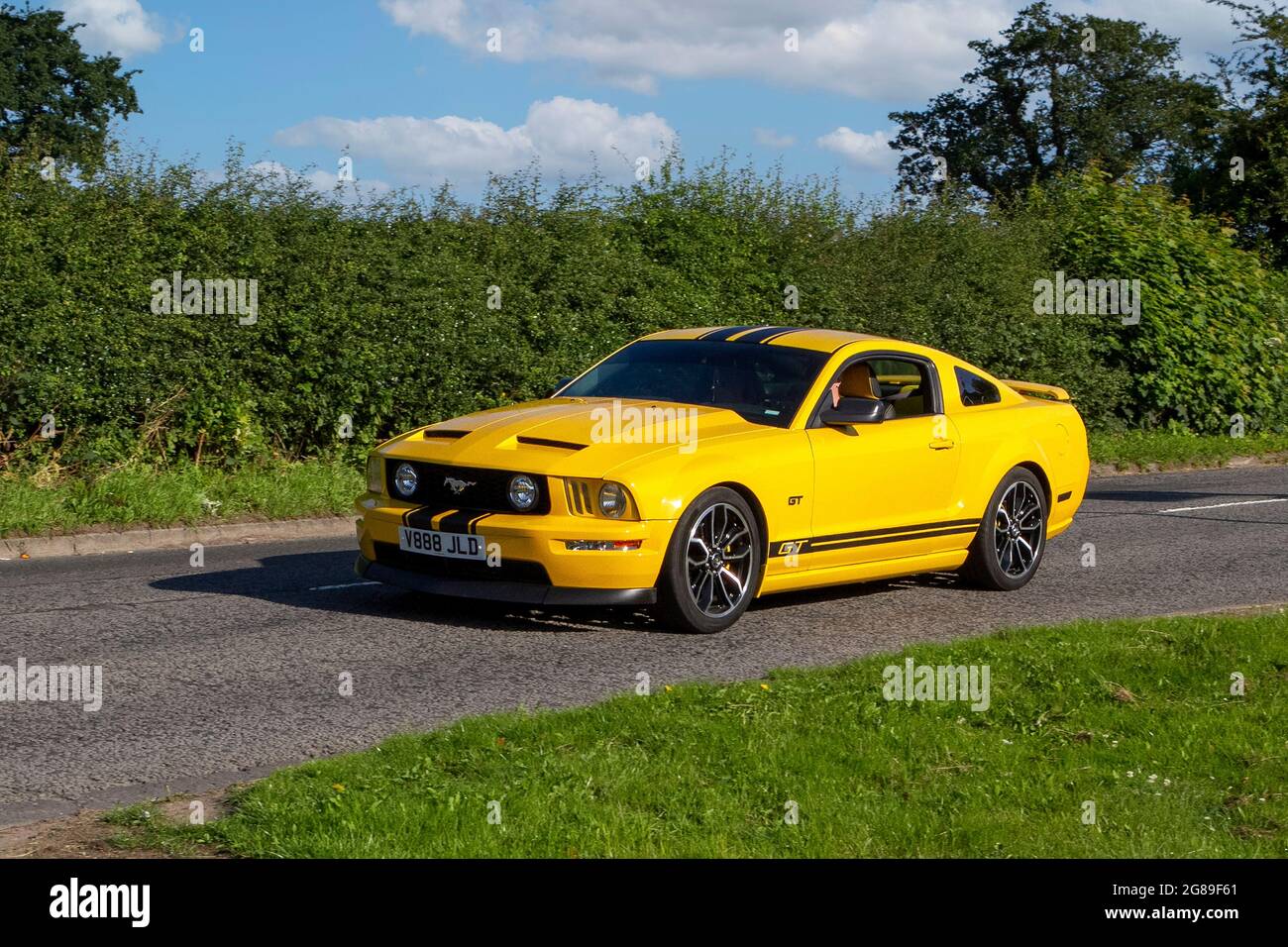 2008 giallo Ford Mustang 2dr Fastback veicolo a benzina lungo il tragitto per Capesthorne Hall Classic luglio mostra auto, Cheshire, Regno Unito Foto Stock