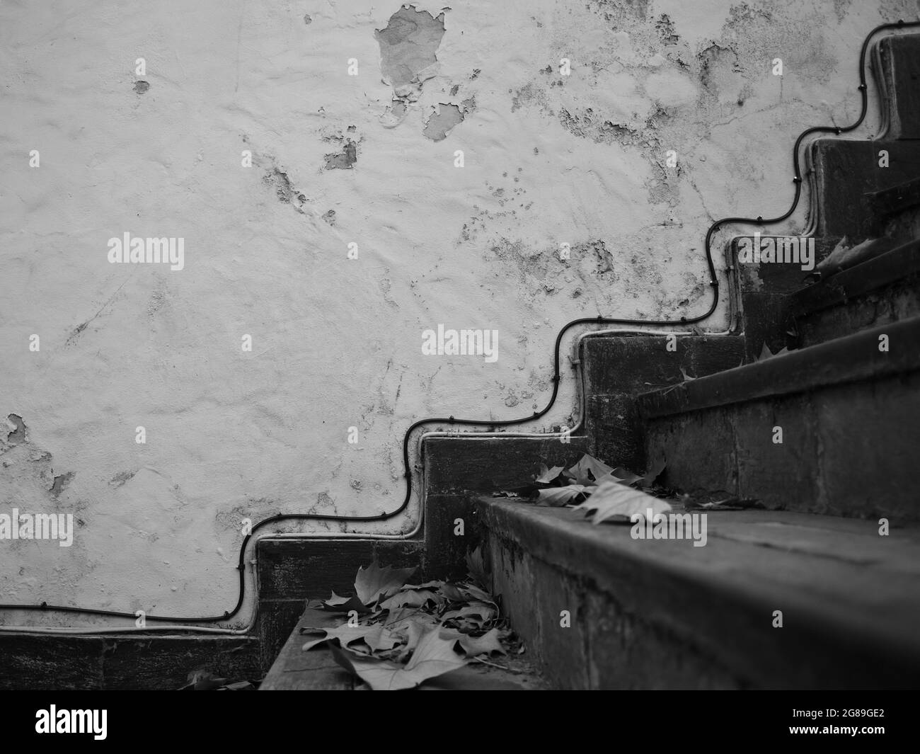 linee parallele in un luogo perduto, cavi alesati alla parete parallelamente alle scale Foto Stock