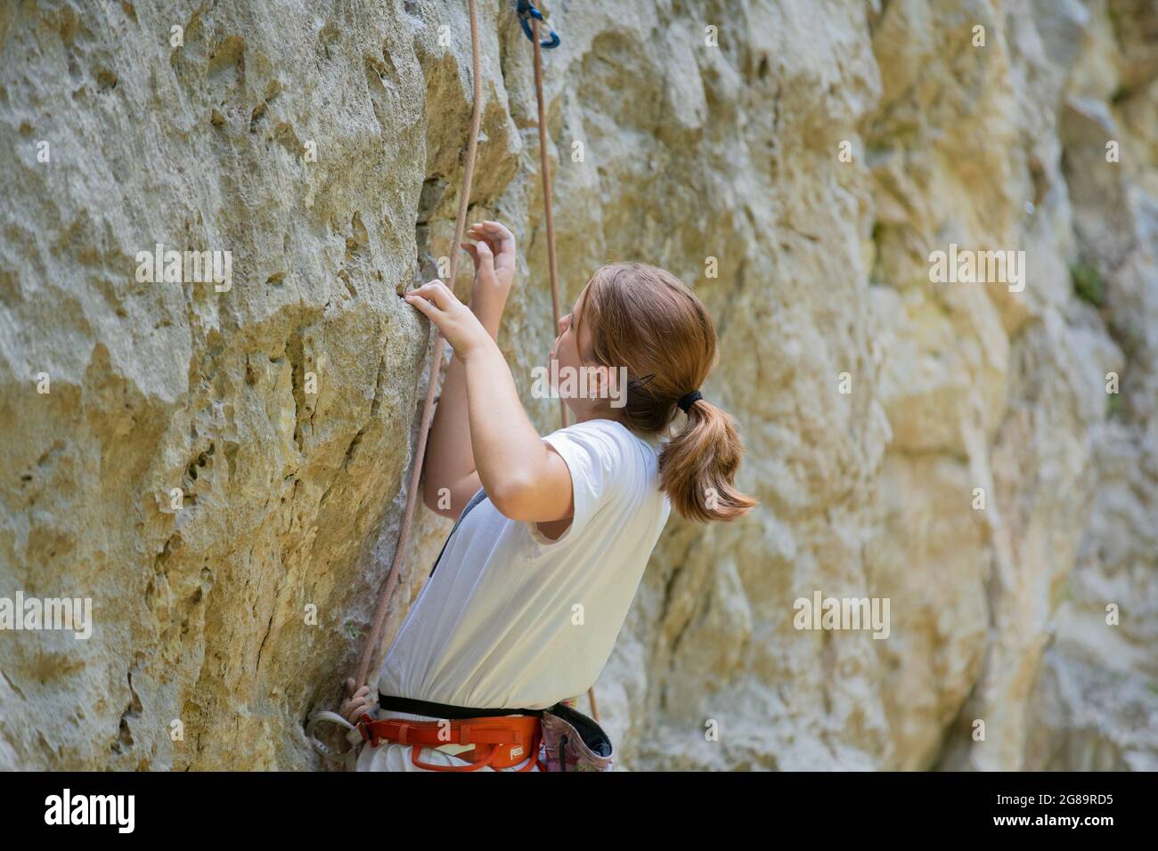 Ragazza adolescente in un difficile tour di arrampicata nella zona di la Gola, Val Sarca, Lago di Garda, Trentino Italia Foto Stock