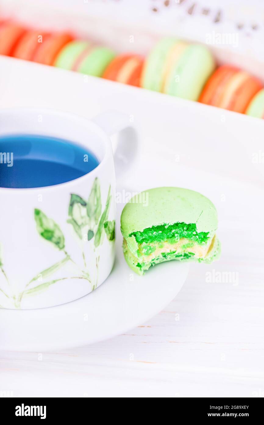 Tazza di porcellana di tè thailandese blu farfalla pisello fiore e amaretto verde amaretto o macaron Foto Stock