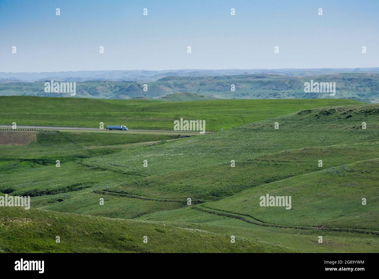 I veicoli viaggiano verso sud sull'Interstate 90 vicino a Story, Wyoming. Trail su collina in primo piano è il percorso del vecchio Bozeman Trail, un ramo dell'Oregon Trail. Foto Stock