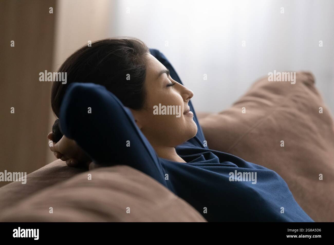 Calma donna indiana rilassarsi sul divano letto Foto Stock