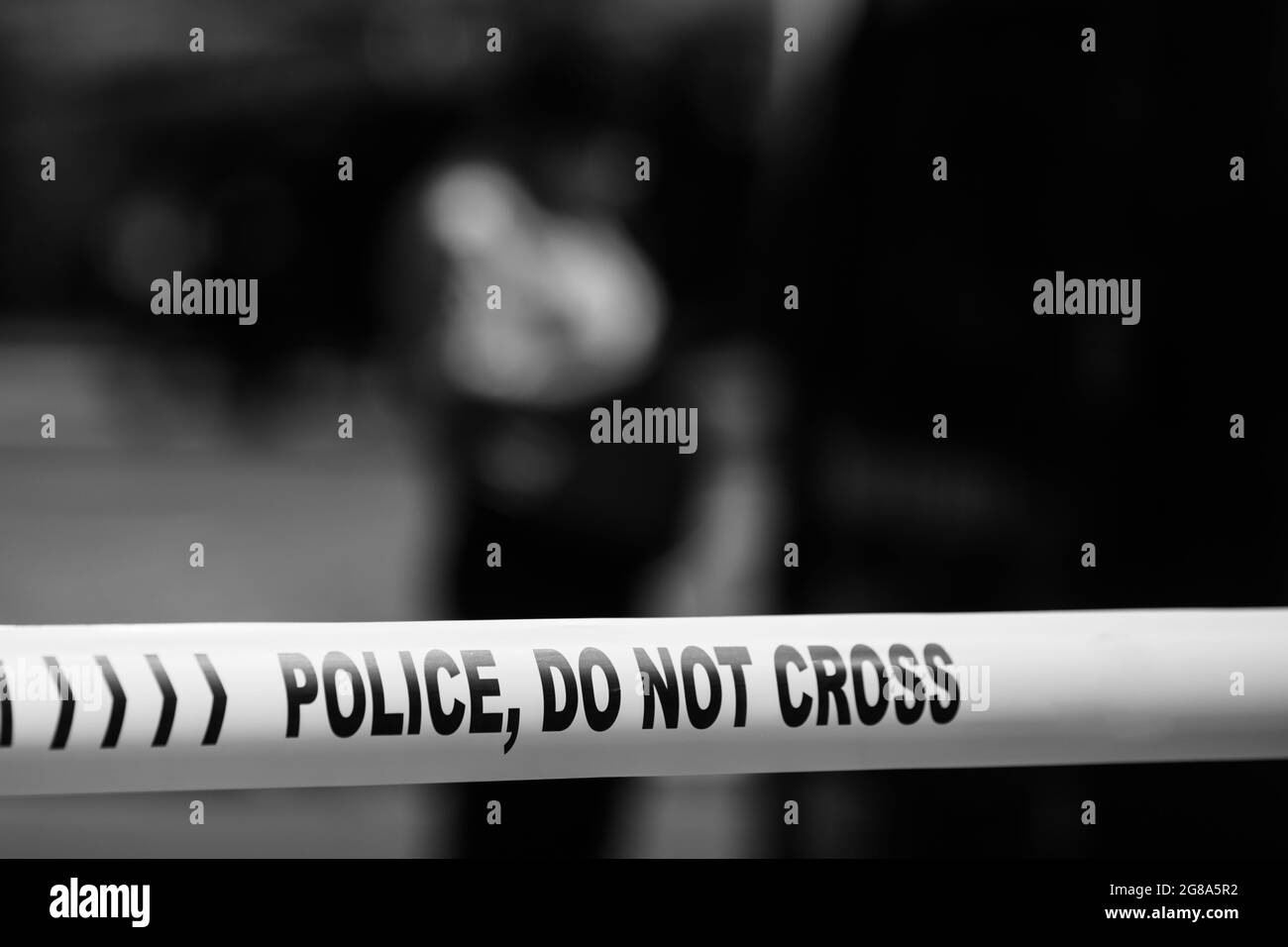 Profondità di campo poco profonda (fuoco selettivo) immagine con nastro di plastica polizia lettura polizia, non attraversare, in una scena di crimine. Foto Stock