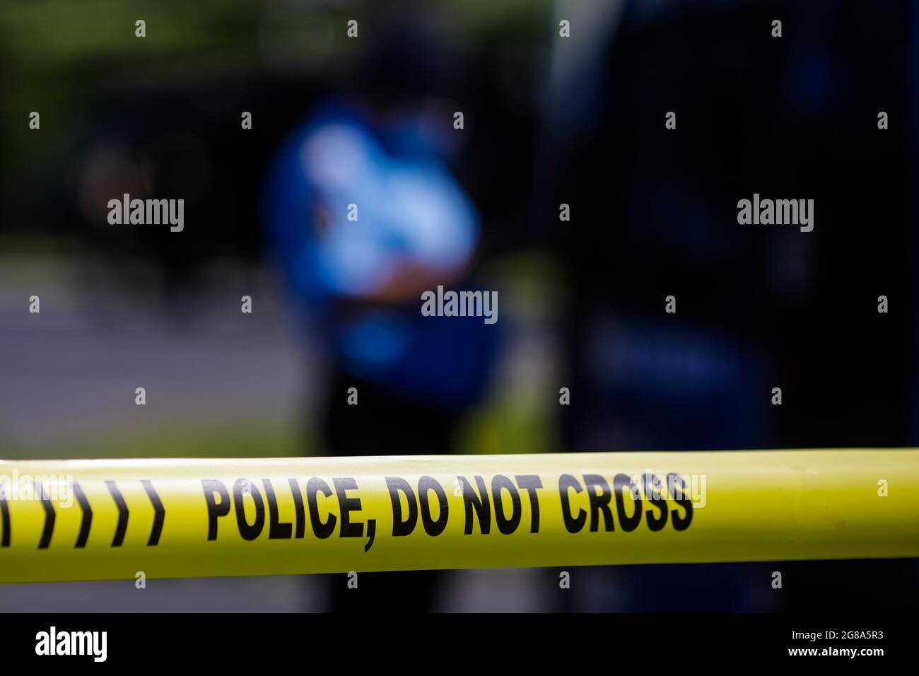 Profondità di campo poco profonda (fuoco selettivo) immagine con nastro di plastica polizia lettura polizia, non attraversare, in una scena di crimine. Foto Stock