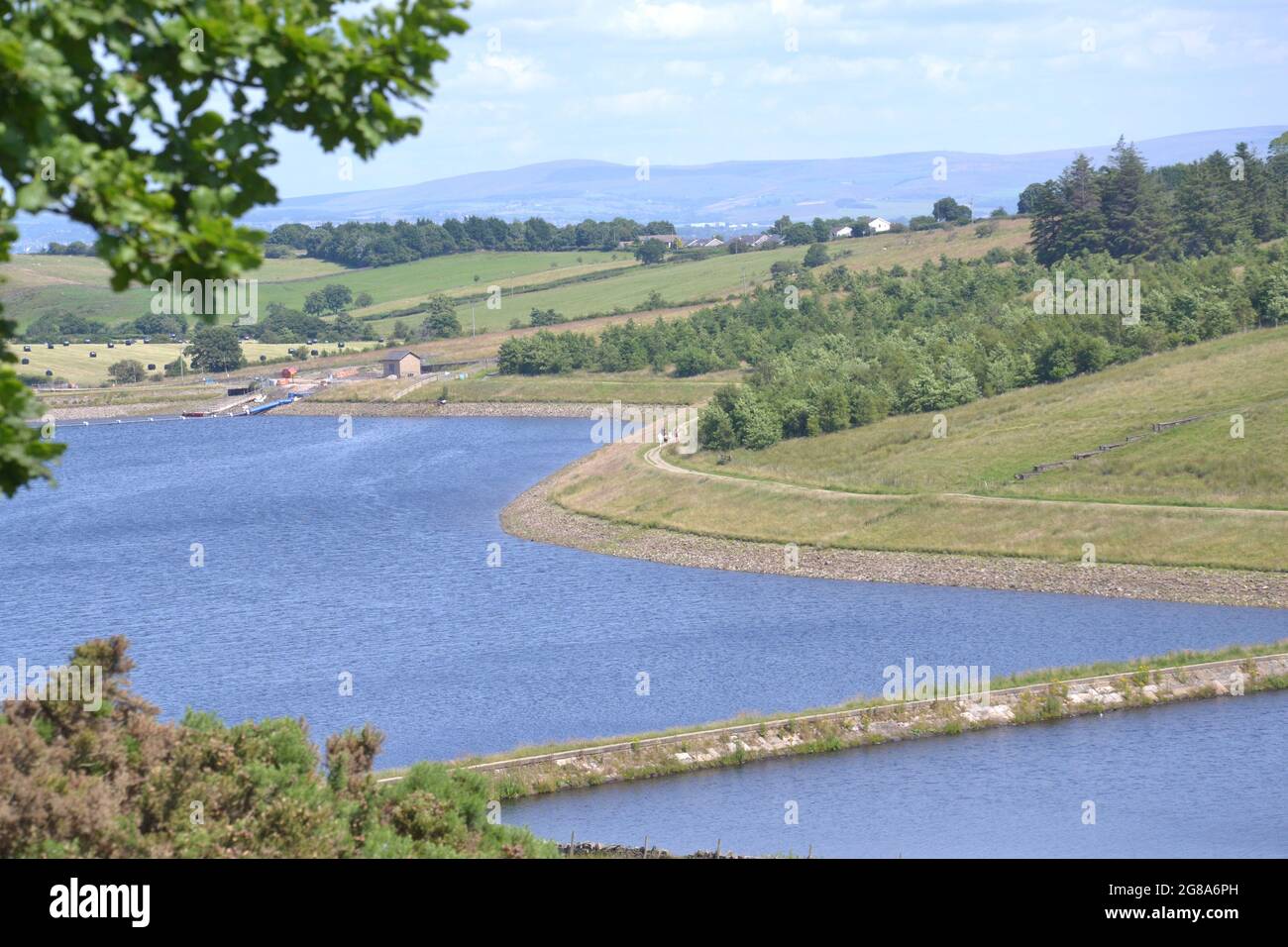 Gli escursionisti e gli escursionisti potranno godersi il sole sotto il cielo blu accanto al lago artificiale Dean Clough, vicino a Langho, Lancashire, Regno Unito, mentre la mini ondata di calore continua nel luglio 2021. La temperatura sta colpendo 30C in alcune parti del Regno Unito. Il 15 luglio 2021 la sanità pubblica Inghilterra (PHE) ha emesso un allarme di salute termica. Foto Stock