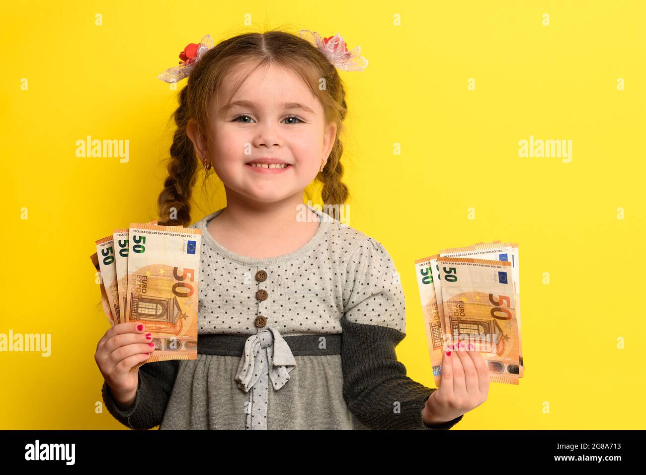 I soldi di risparmio di non-bambino nelle mani dei bambini, sfondo giallo e  soldi con il bambino Foto stock - Alamy