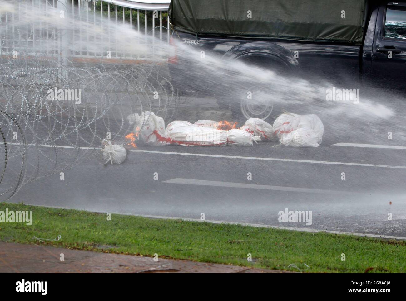 Bangkok, Thailandia. 18 luglio 2021. Cannoni ad acqua spruzzati a covide bruciante 19 simulati morti vittime, durante la dimostrazione al di fuori della Casa del Governo. La polizia di Bangkok ha sparato cannoni ad acqua, proiettili di gomma e gas lacrimogeni nei confronti dei manifestanti pro-democrazia che chiedono al primo ministro Prayut Chan-o-cha di scendere e il governo è ritenuto responsabile della sua cattiva gestione della pandemia del Covid-19. Credit: SOPA Images Limited/Alamy Live News Foto Stock