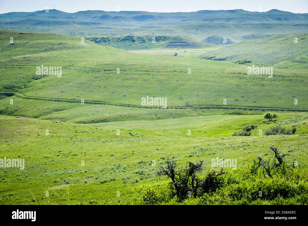 I veicoli percorrono l'Interstate 90 vicino a Story, Wyoming, con i carri del vecchio Bozeman Trail chiaramente visibili sulla collina in mezzo alla distrazione. Foto Stock