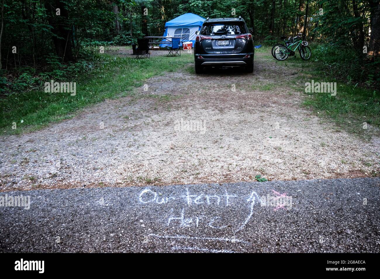 Campeggio nel Rocky Arbor state Park, Wisconsin Dells, Stati Uniti. La nota calciata sull'asfalto dice 'la nostra tenda qui.' Foto Stock