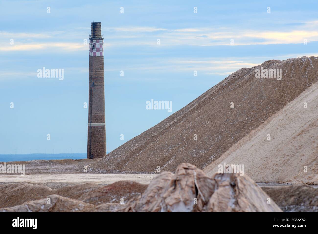 Zielitz, Germania. 16 luglio 2021. Un camino del 'Kaliwerk Zielitz K S minerali e Agricoltura' torreggia su un mucchio di rovina. Nel sito vicino alla capitale dello stato Magdeburg, l'azienda mineraria sali grezzi contenenti potassio, da cui vengono prodotti fertilizzanti al potassio e cloruro di potassio per mangimi o per usi industriali. Credit: Klaus-Dietmar Gabbert/dpa-Zentralbild/ZB/dpa/Alamy Live News Foto Stock