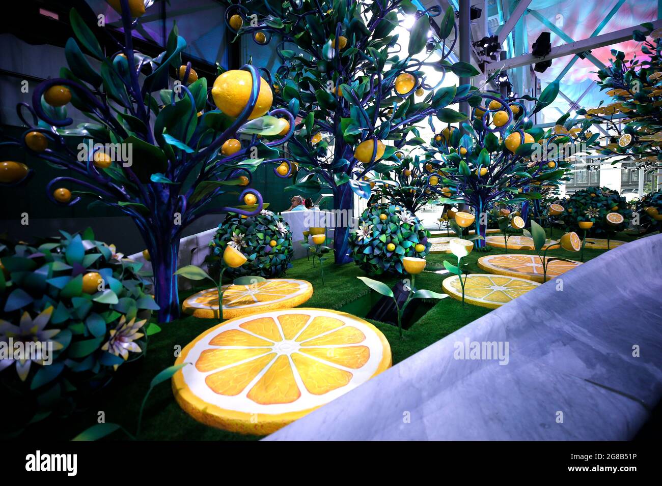 New York, Stati Uniti. 18 luglio 2021. Sculture di alberi di limone fabbricate abbracciano la maggior parte di una piazza pedonale di Midtown, New York City.Citrovia è un paesaggio costruito con alberi di limone artificiali surreali e limoni giganteschi che crescono dal suolo. Gli alberi e i limoni dipinti a mano insieme ai tessuti multicolore che si avvolgono con il vento, progettati per simulare le nuvole, sono stati destinati a mascherare il ponteggio durante la costruzione lungo lo sviluppo ad uso misto a "Manhattan West" Plaza . Credit: SOPA Images Limited/Alamy Live News Foto Stock