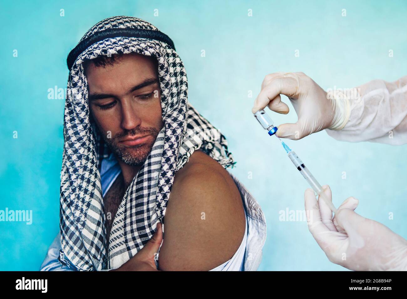 Un uomo paziente in abiti arabi su appuntamento di un medico. Vaccinazione dei paesi del Medio Oriente. Concetto medico Foto Stock