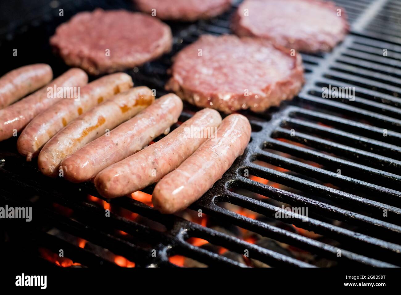 Hamburger al Grill con fiamme danzanti cucinate alla perfezione Foto Stock