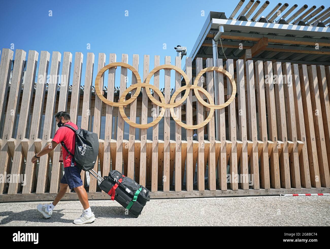 Tokio, Giappone. 19 luglio 2021. Un uomo del Team Mexico cammina attraverso gli anelli olimpici all'ingresso del Villaggio Olimpico. Il Villaggio Olimpico è un complesso residenziale che ospiterà i partecipanti ai Giochi Olimpici del 2020. Le Olimpiadi di Tokyo 2020 si terranno dal 23 luglio 2021 all'8 agosto 2021. Credit: Michael Kappeler/dpa/Alamy Live News Foto Stock