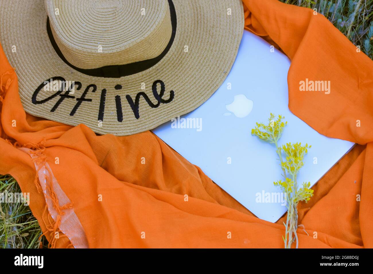 Un cappello di paglia con una parola scritta Offline. Uno sfondo arancione,  un notebook grigio piatto. Mancanza di connessione a Internet. Concetto di  pausa nel lavoro, busine Foto stock - Alamy