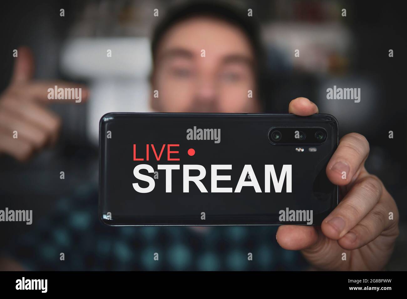 Bell'uomo che fa il video blog. Focus su smartphone. Giovane blog video spara contenuti per il suo video blog su un social network. Trasmissione in tempo reale tramite Foto Stock