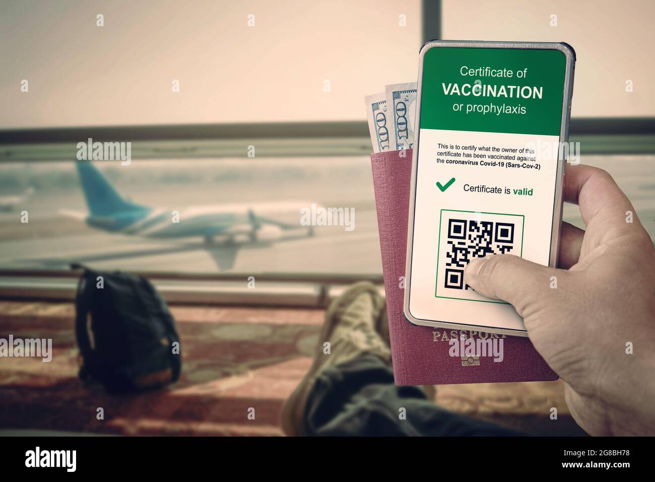 smartphone con codice qr nell'app per confermare la vaccinazione o un test negativo per covid-19. un uomo ha un passaporto e uno smartphone presso l'aeroporto agai Foto Stock